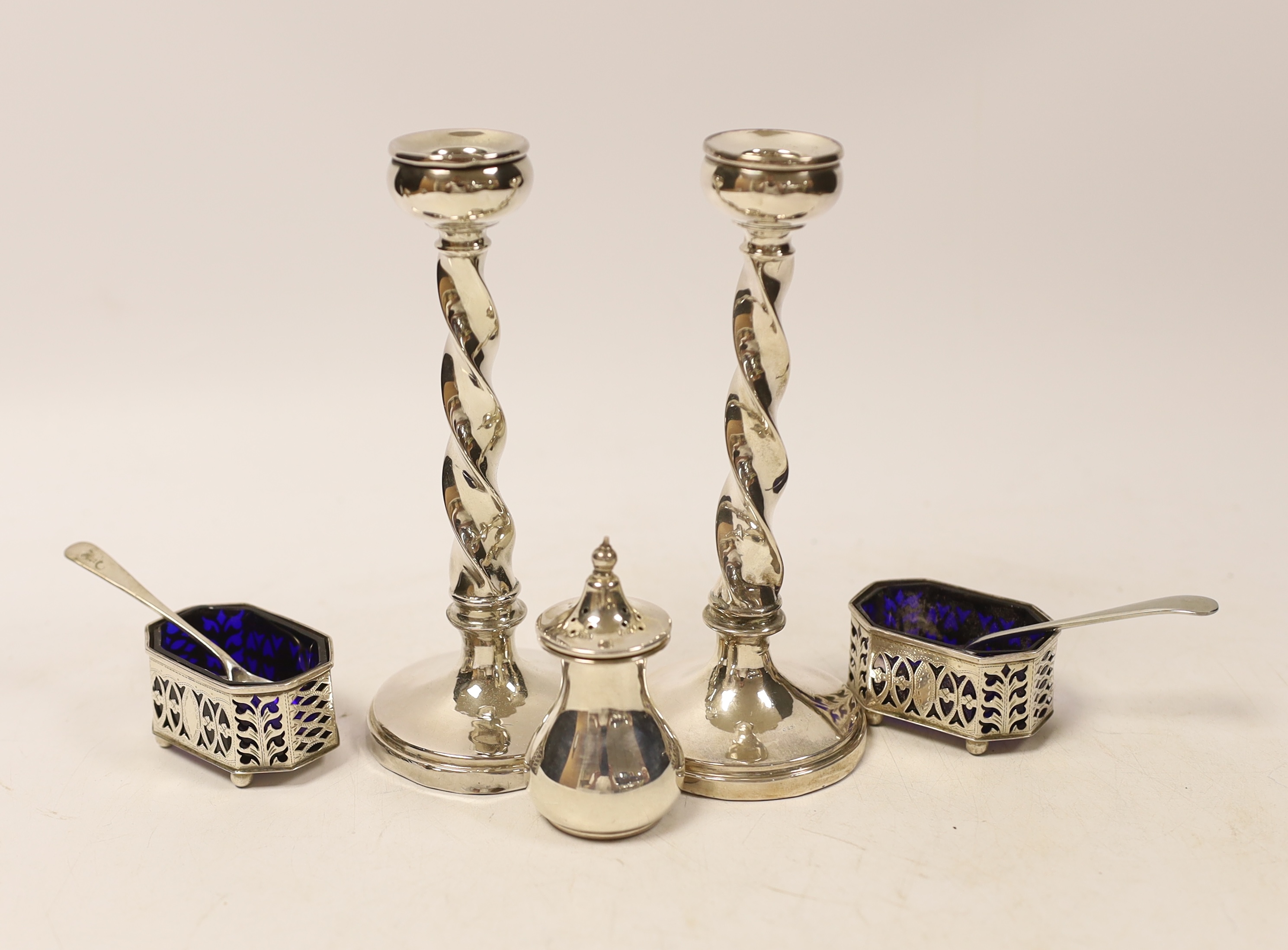 A pair of silver mounted candlesticks, marks rubbed and three silver condiments with two spoons, one plated. etc. (4)